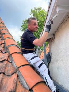 Schilder schildert veilig de boeiplanken met de verfblikhouder | Paintholder