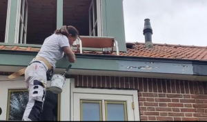 "Schilder gebruikt de Paintholder om veilig en efficiënt een dakkapel te schilderen"